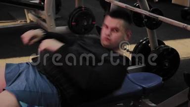 快乐的胖子在健身房里执行错误的长凳<strong>按压</strong>。